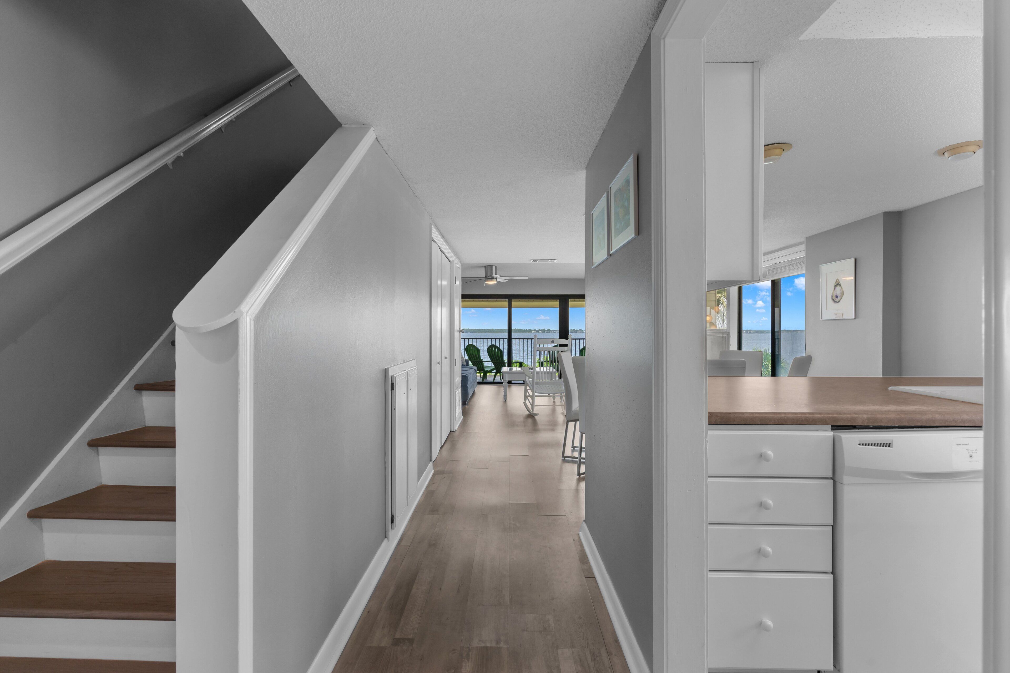 A modern kitchen with white cabinetry, a wooden countertop, and a view to the outside.
