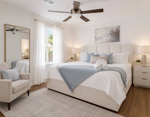 A bedroom with a bed, bedside tables, a chair, a ceiling fan, and a painting on the wall. - Day Dreams Begin at Bryant Denny Stadium 6 ppl (Tuscaloosa)