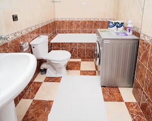 Ein Badezimmer mit Toilette, Badewanne und Waschmaschine.
