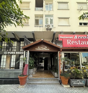 Un edificio con un letrero de restaurante, un letrero de Pure Bedd y un letrero de Residence Racha.