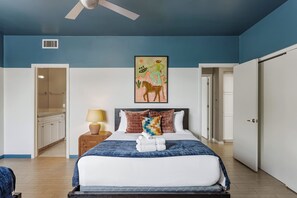 A bedroom with a bed, a nightstand, a lamp, a ceiling fan, and a painting on the wall. - Lyra - Dual Retreat - In Old Town Scottsdale (Scottsdale)
