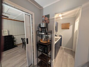 Eine kleine Küche mit Kaffeemaschine, Toaster und Spüle.