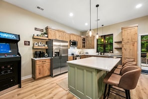 Une cuisine moderne avec des meubles en bois, des appareils en acier inoxydable et un coin bar.