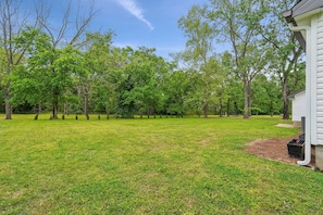 A grassy yard with trees and a house. - Vintage-Charm Cottage Near 386, 25 Min to Downtown Nashville (Gallatin)