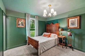 A bedroom with a bed, a nightstand, a lamp, and a window with curtains. - Vintage-Charm Cottage Near 386, 25 Min to Downtown Nashville (Gallatin)