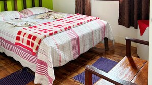 A room with a bed, wooden headboard, a window with curtains, and a wooden chair. - Pousada Cantinho Gostoso (Ouro Preto)