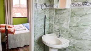 A bathroom with green marble tiles, a white sink, and a window with curtains. - Pousada Cantinho Gostoso (Ouro Preto)