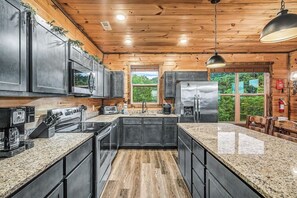 Eine moderne Küche mit Granit-Arbeitsplatten, Edelstahlgeräten und Holzschränken.