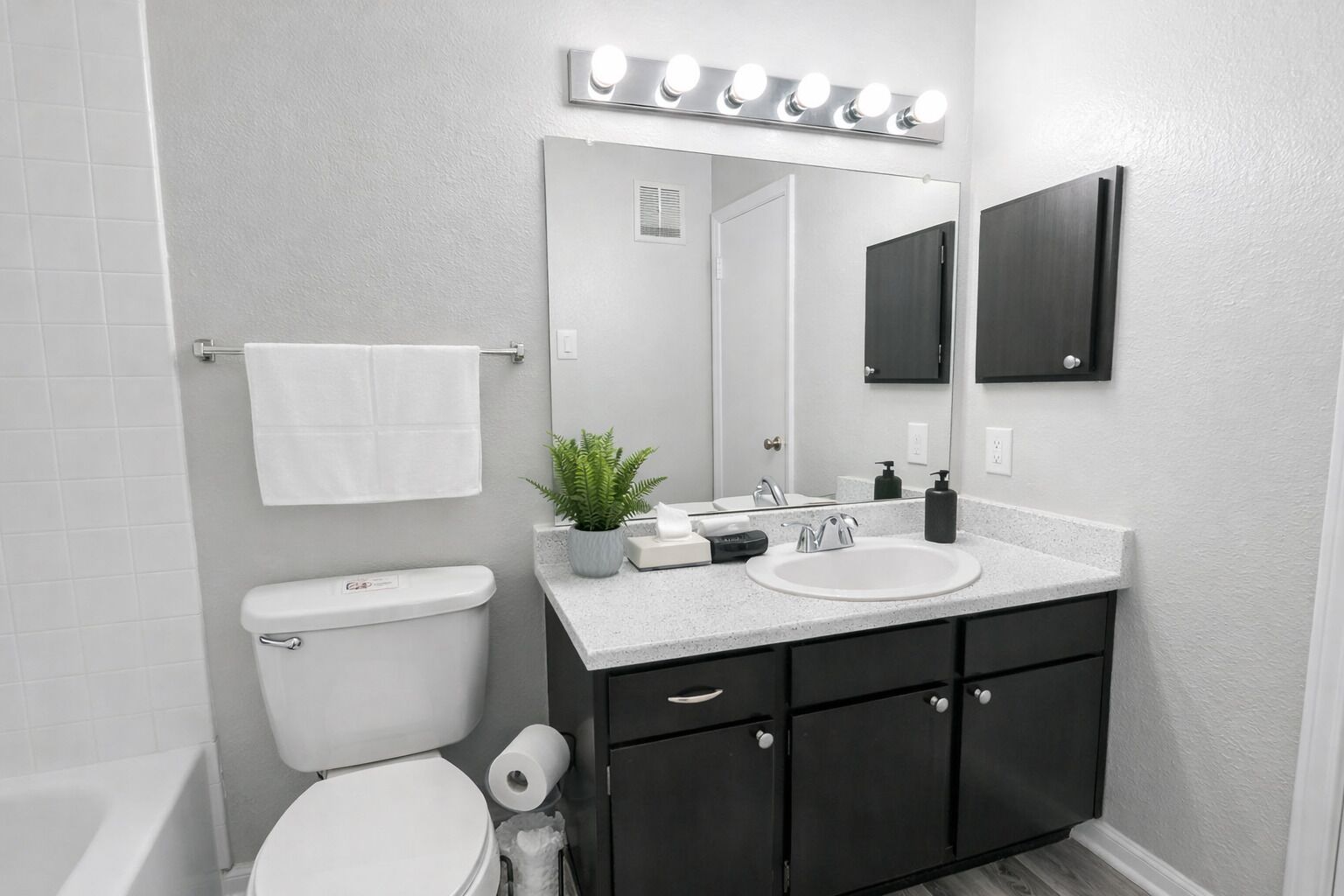 Een moderne badkamer met toilet, wastafel en een badkamermeubel.