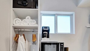 Una kitchenette compacta con microondas, un refrigerador pequeño y una cafetera.