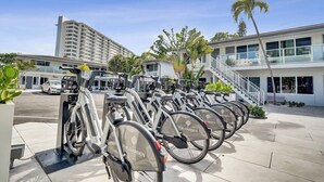 A row of stationary bikes with 'The Garden' branding, a modern building with a staircase, and a palm tree in the background. - Fort Lauderdale King Room at Botanica (Fort Lauderdale)