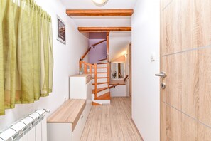 A narrow hallway with a wooden staircase, a radiator, and a door with a wooden frame. - House 2442/251993 (Istria - Vodnjan), 8000m from the beach (Vodnjan)
