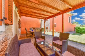 A covered outdoor seating area with wicker furniture and a stone wall. - House 2442/251993 (Istria - Vodnjan), 8000m from the beach (Vodnjan)