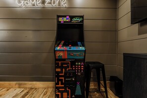 Een retro speelautomaat met een neonreclame op de achtergrond.