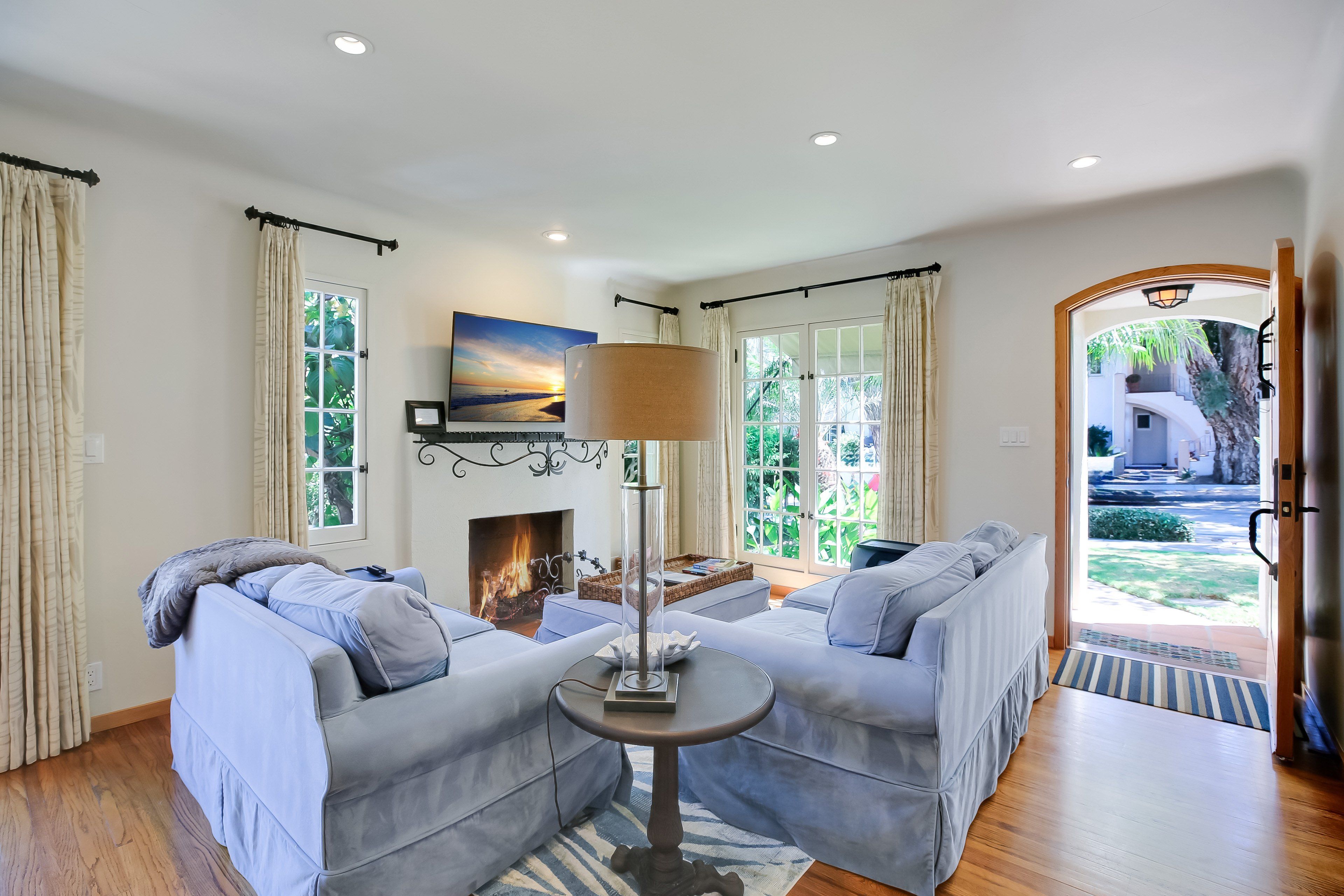 A living room with two sofas, a fireplace, and a view of the outdoors.
