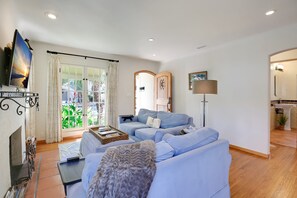 A living room with a sofa, a television, and a fireplace. - New! Casa Capricho in West Beach with A/C, private yard, walk to beach (Santa Barbara)