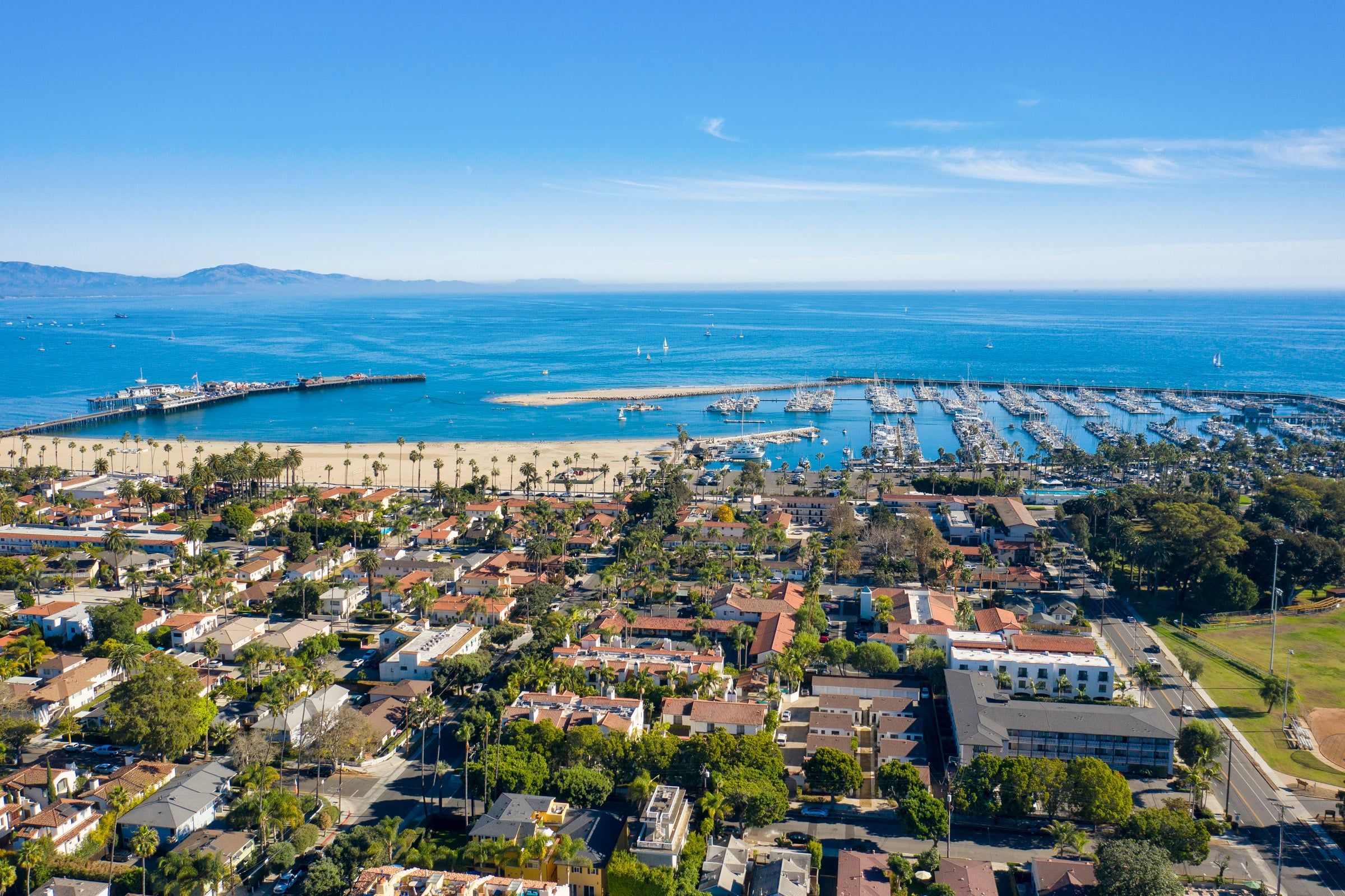 A coastal town with a marina, residential buildings, and a beach.