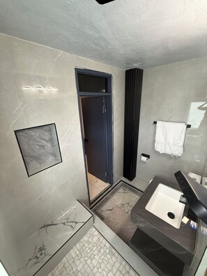 A modern bathroom with a marble floor, a black bathtub, a glass shower enclosure, and a towel rack. - Luxury 2 bed 2 bath at Sandcastle Ocho rios (Ocho Rios)