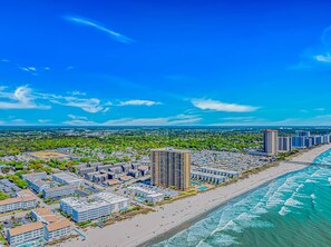 A coastal cityscape with a beachfront hotel, high-rise buildings, and a clear blue sky. - Oceanview 3BR | Balcony+Elevator | Steps to Beach (Myrtle Beach)