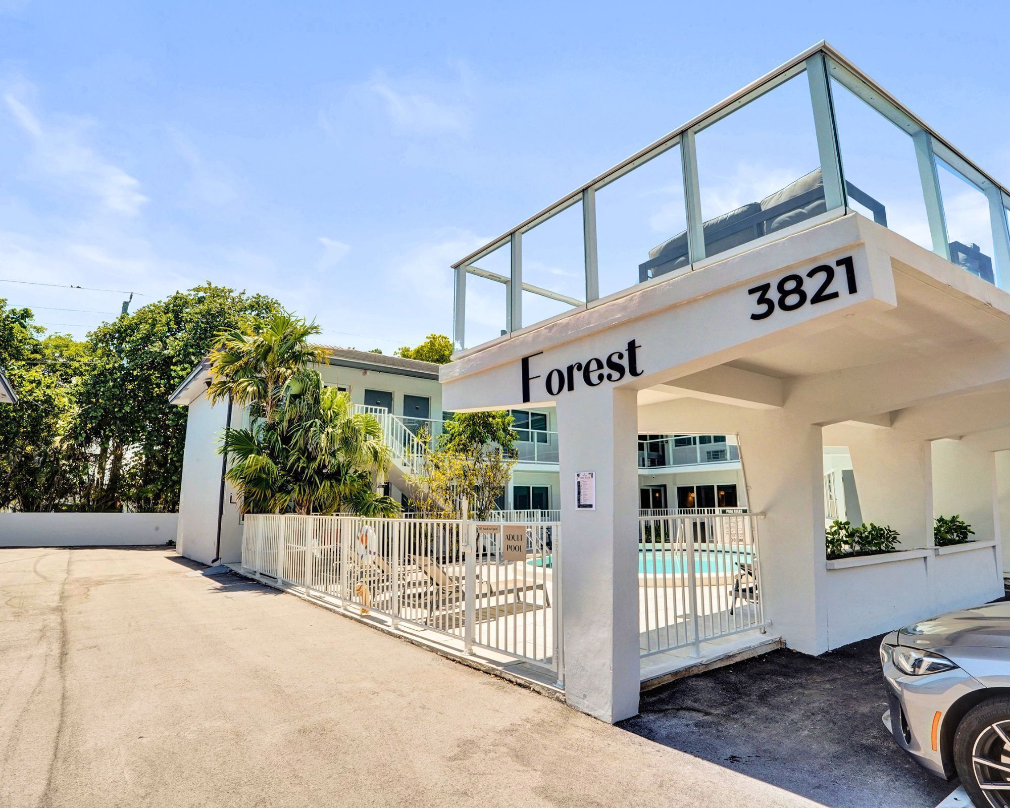 Ein modernes Gebäude mit einem Glasbalkon, beschriftet mit 'Forest 3821', und einem verschlossenen Eingang.