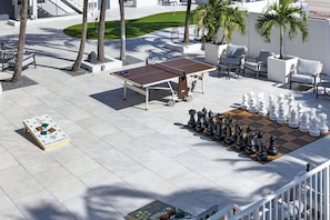 A chessboard set up on a patio with a table and chairs nearby. - The Botanica - Forest (Fort Lauderdale)