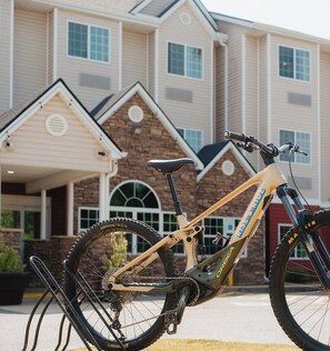 A mountain bike parked in front of a house with a garage and a driveway. - Independent Boutique Hotel Near Bentonville's Top Sights (Bentonville)