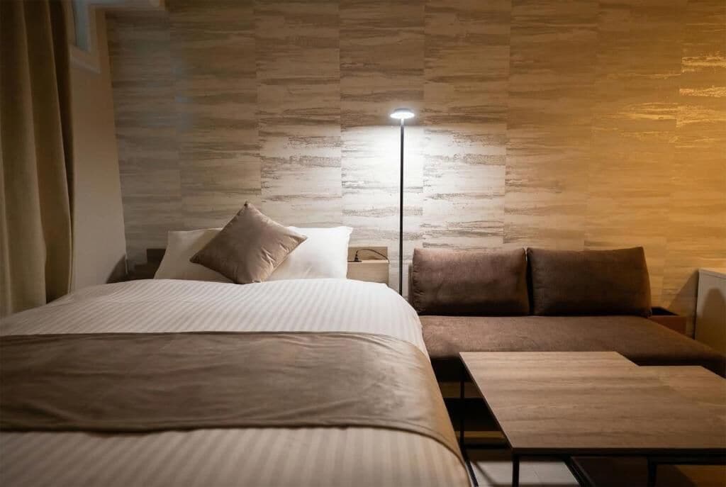 Ein modernes Schlafzimmer mit Bett, Sofa und Nachttisch.