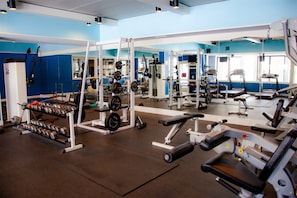 Ein Fitnessstudio mit Gewichten, Laufbändern und Trainingsgeräten.