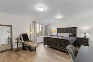 A bedroom with a bed, a chair, a desk, a dresser, and a mirror. - Arrowleaf | Golf & Pond Views | Ground-Floor Kahler Glen Condo | Sleeps 4 (Leavenworth)