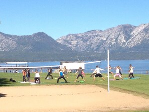 A group of people exercising on a grassy field with mountains in the background. - Regan Beach Retreat Cabin | CYH0809 (South Lake Tahoe)