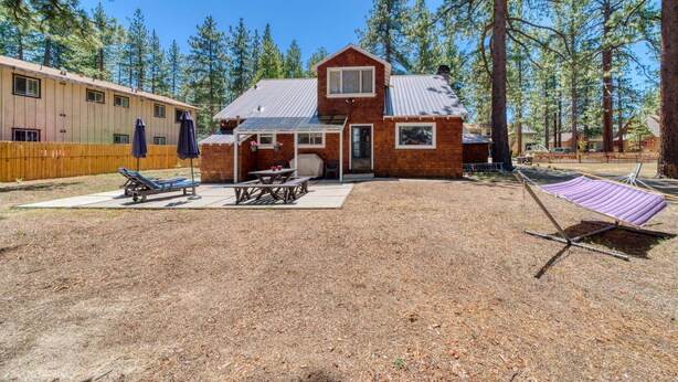 A two-story house with a patio, a barbecue grill, and a hammock. - Regan Beach Retreat Cabin | CYH0809 (South Lake Tahoe)