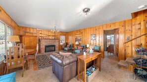 A log cabin interior with a fireplace, leather sofa, dining table, and wooden walls. - 1 Block from Regan Beach | BBQ | Deck (South Lake Tahoe)