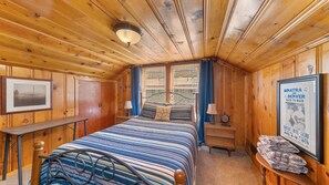 A cozy wooden room with a bed, a desk, a framed picture, and a poster. - 1 Block from Regan Beach | BBQ | Deck (South Lake Tahoe)