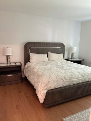 Ein Schlafzimmer mit einem Bett, zwei Nachttischen und einer Lampe.