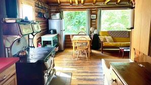 Una cocina rústica con vigas de madera, una estufa y un refrigerador.