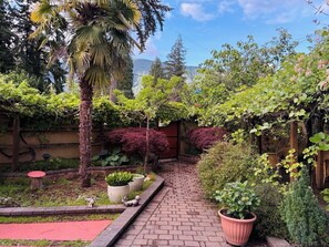 Ein Gartenpfad mit verschiedenen Pflanzen und einer Holzkonstruktion.