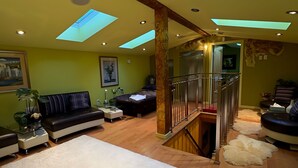A spacious living area with a high ceiling, skylights, a staircase, and a modern design. - Casa Capilano (North Vancouver)