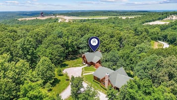 A lodge surrounded by dense forest with a clear sky.