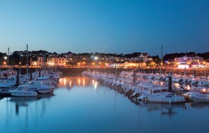 A marina with boats docked, calm water, and buildings in the background. - Charmante maison en Vendée (Moutiers-Les-Mauxfaits)