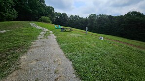 A gravel path leading to a picnic area with a sign indicating 'Camp A'.