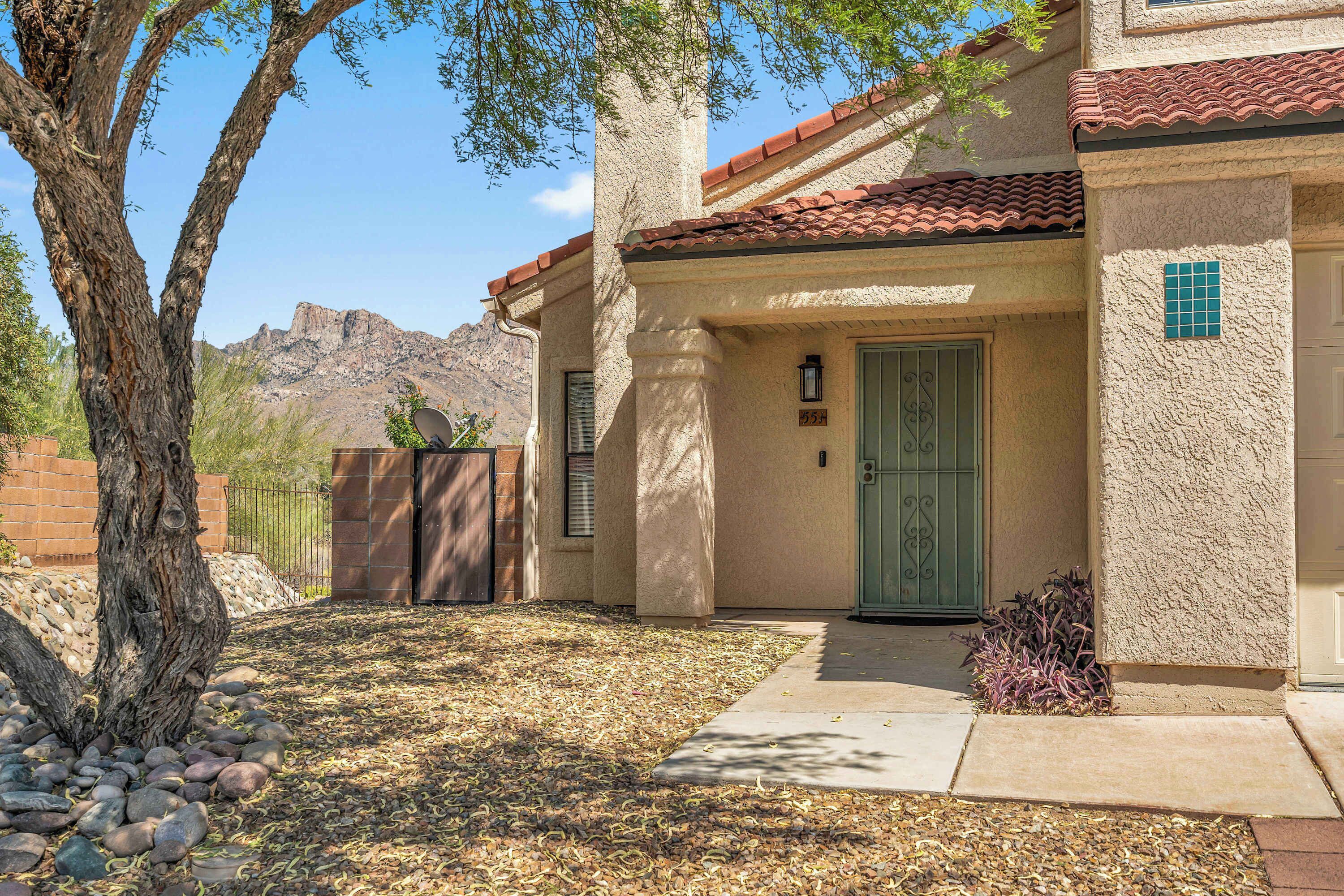 A house with a stone facade, a green door, and a mountain view.
