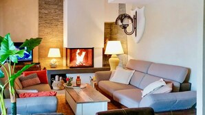 A living room with a fireplace, sofas, a coffee table, and a television. - Lovely home in Lorgues (Lorgues)