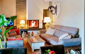 A living room with a fireplace, sofas, a coffee table, and a television. - Lovely home in Lorgues (Lorgues)