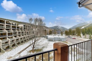 A multi-story parking garage with a clear view of the surrounding mountains and a parking lot. - Mountain view condo w/ shared pool, hot tub, gym (Keystone)