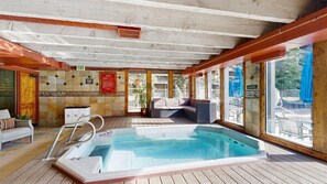 A wooden deck with a hot tub, seating area, and a view of the outdoors. - Mountain view condo w/ shared pool, hot tub, gym (Keystone)