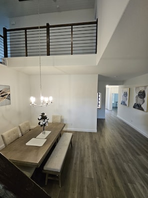 A spacious dining area with a high ceiling, a chandelier, and a view of the upper floor. - Songbird Luxury Retreat — a Modern 4BR Getaway in Wylie, Near Lake Lavon (Wylie)