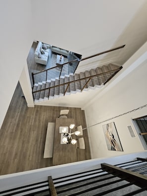 A modern interior with a staircase, a sofa, a coffee table, and a chandelier. - Songbird Luxury Retreat — a Modern 4BR Getaway in Wylie, Near Lake Lavon (Wylie)