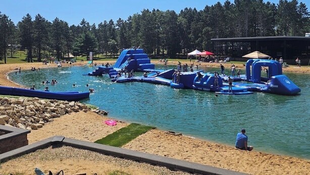 A water park with inflatable structures and a sandy beach area.