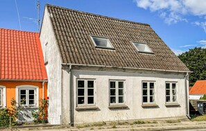 A two-story building with a sloped roof, multiple windows, and a visible antenna. - Amazing home in søby ærø with WiFi (Søby Ærø)