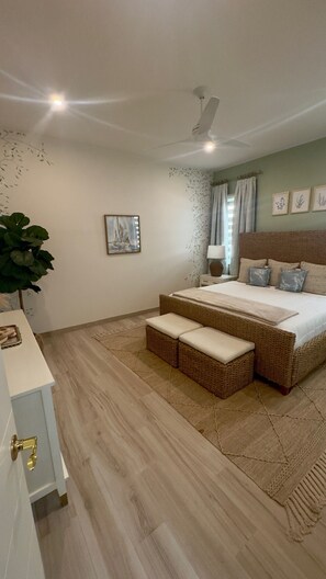 A bedroom with a bed, bedside table, lamp, and a large plant. - Luxury 4BDR Casita 30 with Rooftop Lounge with Ocean View & private Jacuzzi (Diamante)